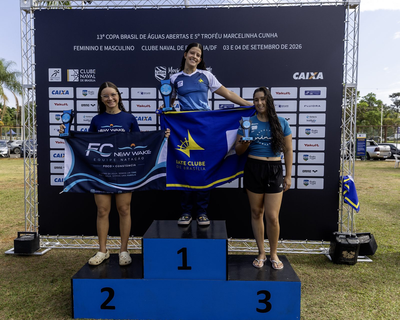 Pódio feminino dos 2,5 km: Juliana Almeida Santos no lugar mais alto com a bandeira do Iate Clube de Brasília, Julia Basile Costa em segundo com a bandeira do New Wake e Sofia Trancoso Duailibe em terceiro